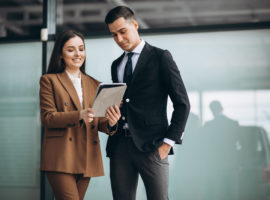 Male and female business people working on tablet in office